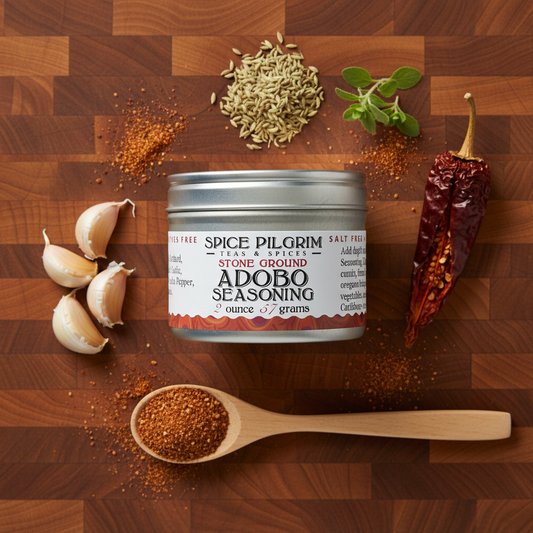 Spice Pilgrim Adobo seasoning can on a wooden surface with ingredients