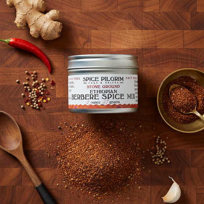 Spice Pilgrim Ethiopian Berbere Spice Mix on a wooden surface with ingredients.
