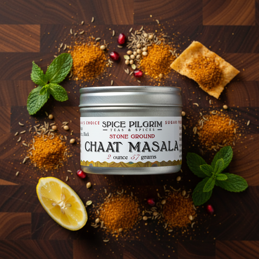 Spice Pilgrim Chaat Masala container surrounded by spices and herbs on a wooden surface